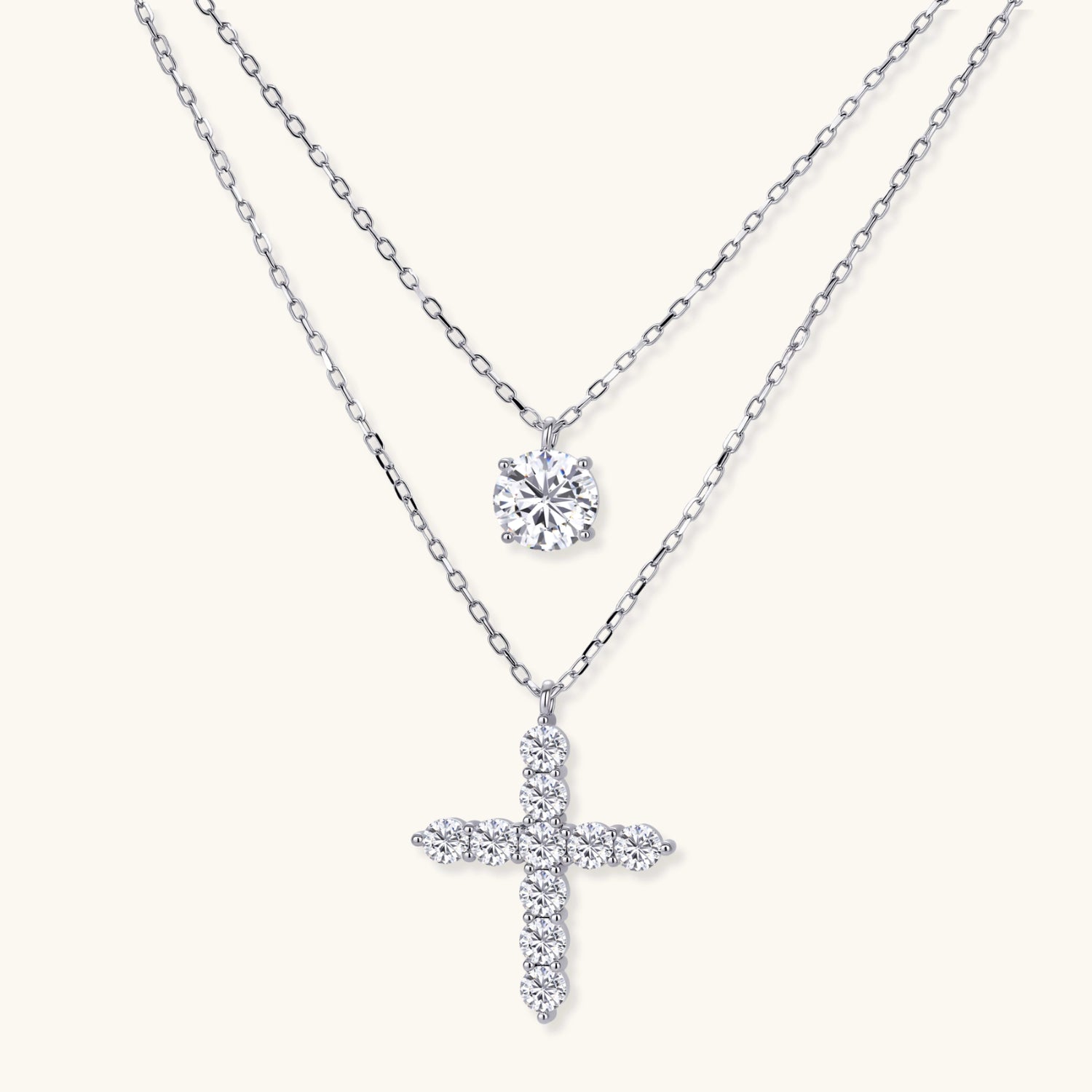 Two delicate sterling silver necklaces with moissanite stones - one solitaire pendant and one cross pendant on white background.